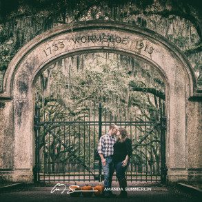 engaged couple poses in front of wormsloe plantation historic site gates